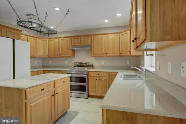 a kitchen with stainless steel appliances granite countertop a sink a stove and a refrigerator