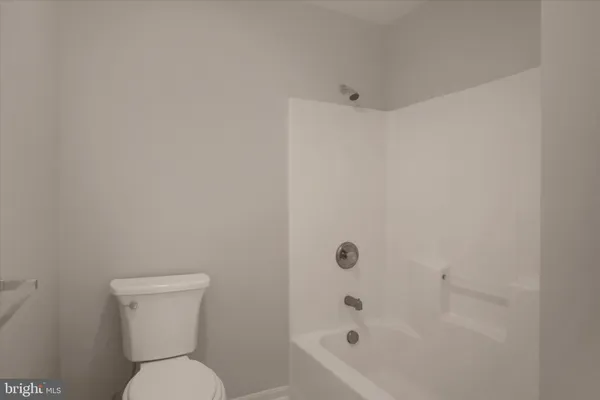 a white toilet sitting next to a bath tub
