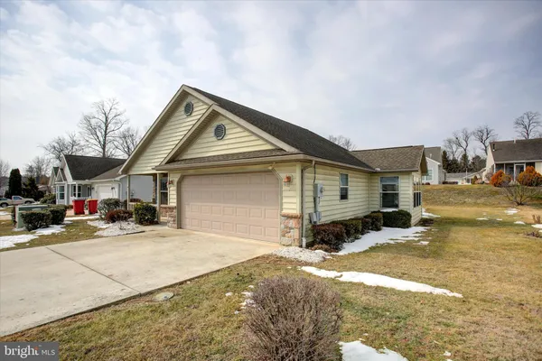 a front view of a house with a yard and potted plants
