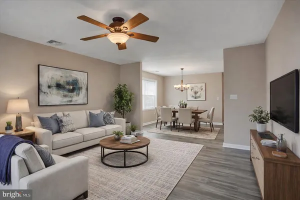 a living room with furniture and a flat screen tv with wooden floor