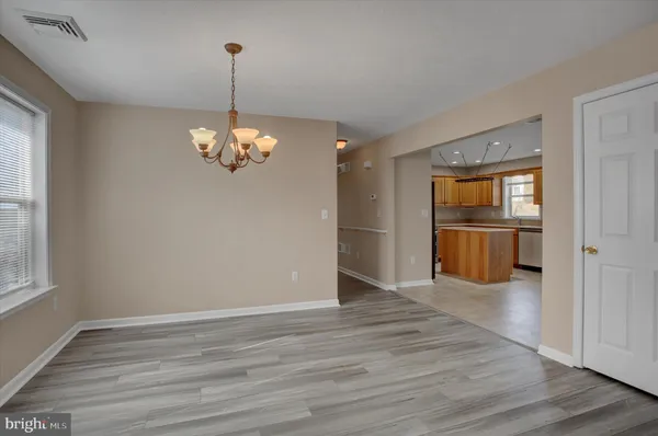 a view of a kitchen with a refrigerator a ceiling fan and wooden floor