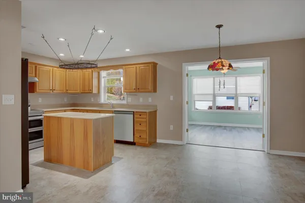 a kitchen with kitchen island granite countertop a stove a sink and a refrigerator