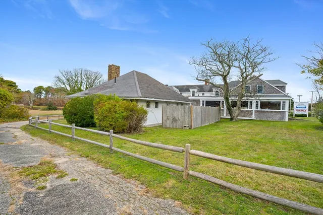 a view of a yard in front of a house with large trees