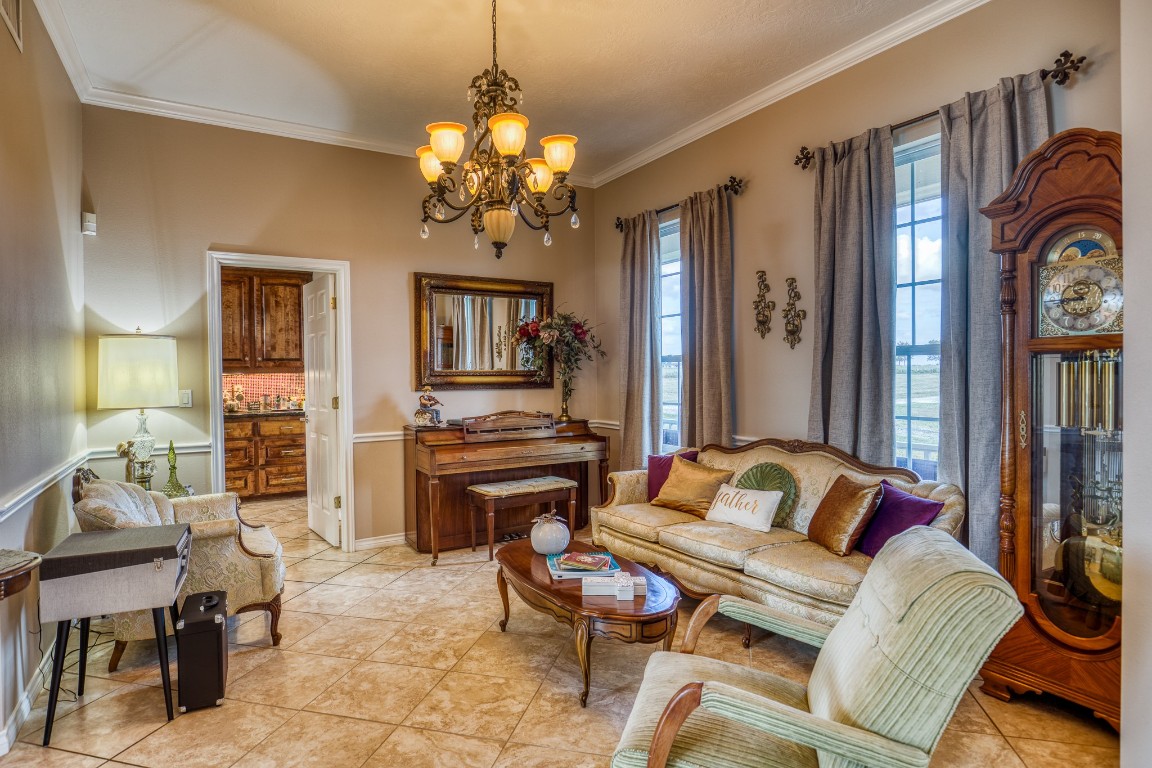 4701 Cedar Hill Road Brenham, TX 77833 - Photo 34 of 50 a living room with furniture a chandelier and a flat screen tv