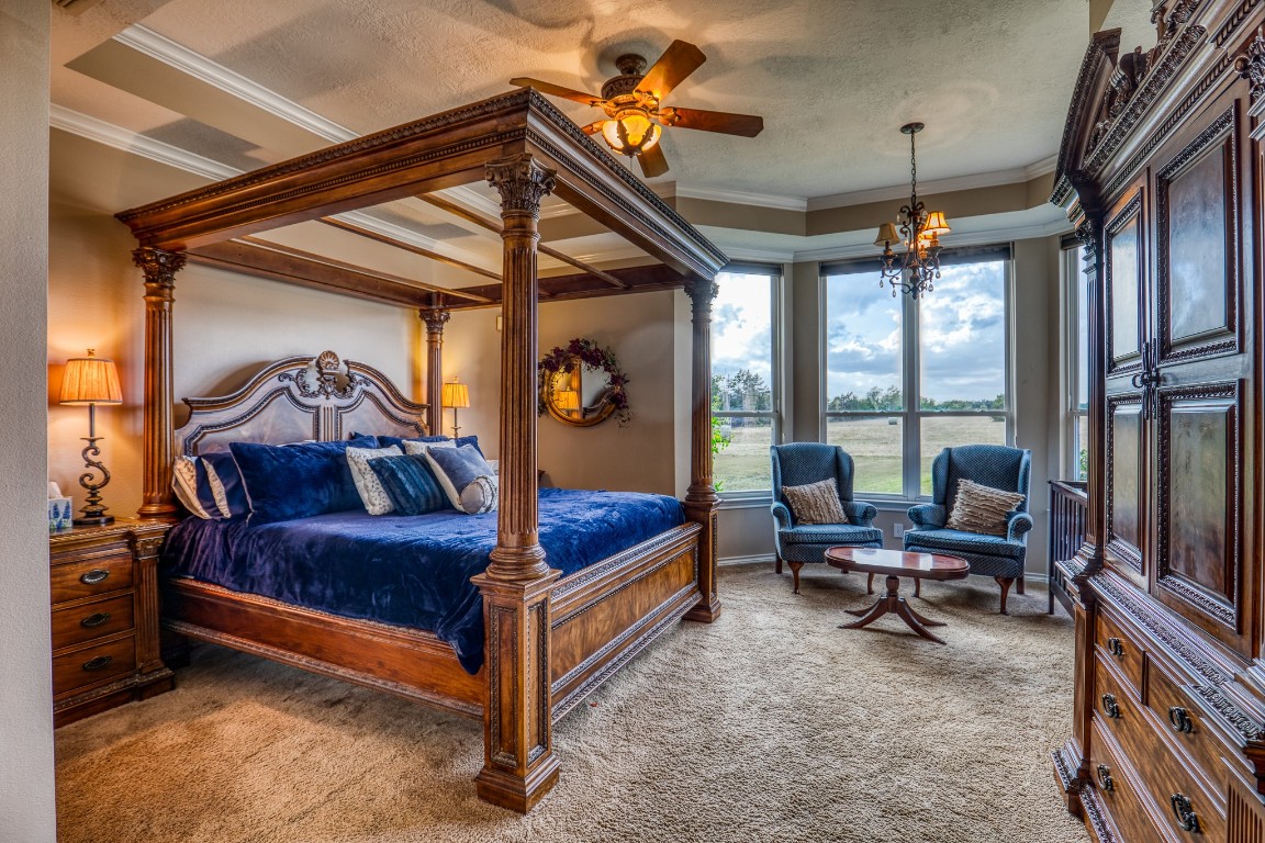 4701 Cedar Hill Road Brenham, TX 77833 - Photo 9 of 50 a spacious bedroom with a bed and a chandelier