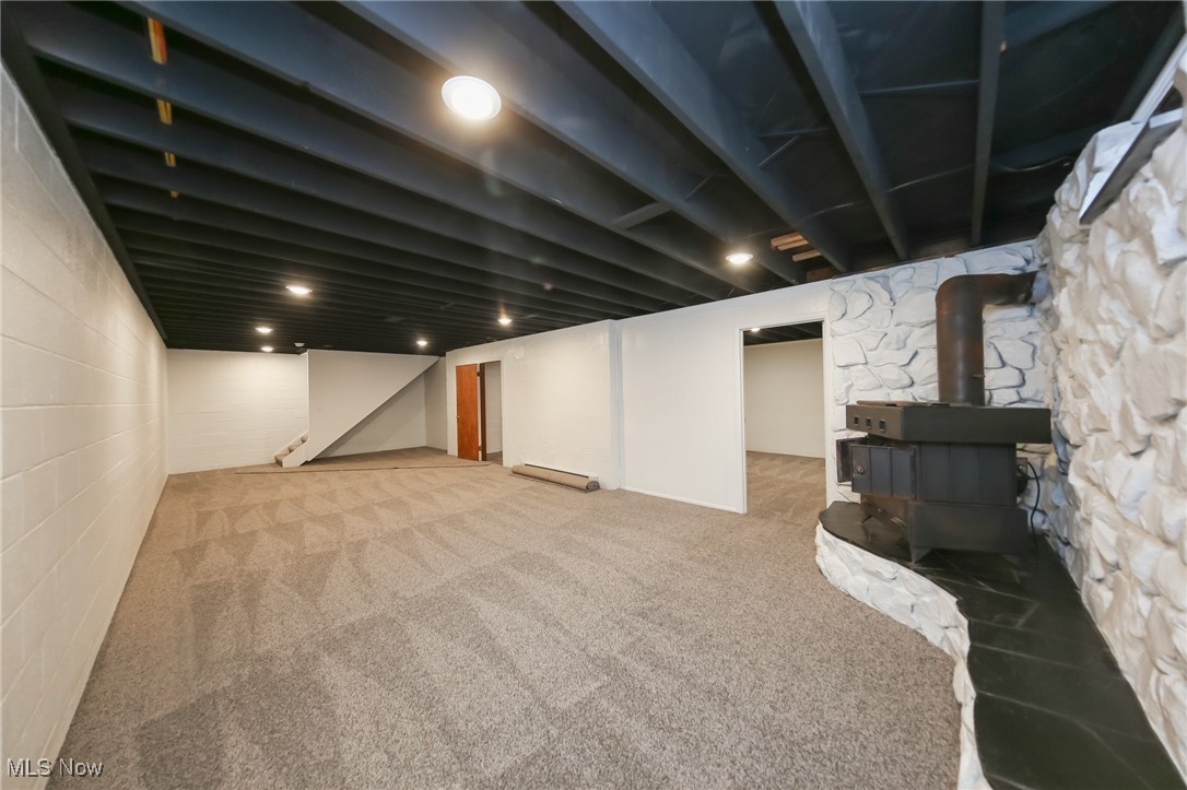 6544 Neff Road Valley City, OH 44280 - Photo 33 of 45 Basement with a wood stove, light carpet, and a baseboard radiator