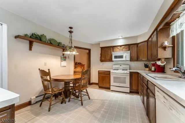 a kitchen with a table chairs microwave and cabinets