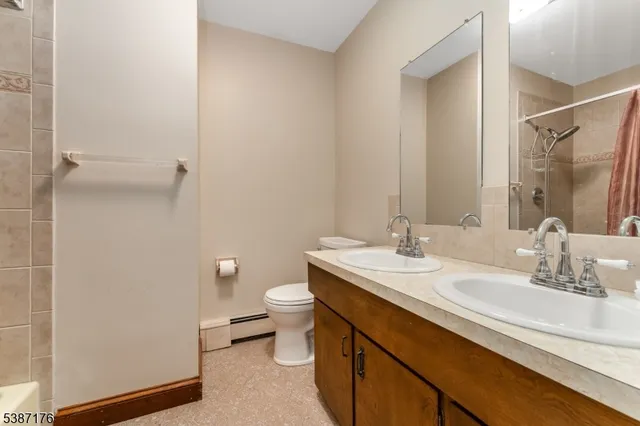 a bathroom with a granite countertop sink a toilet and a mirror