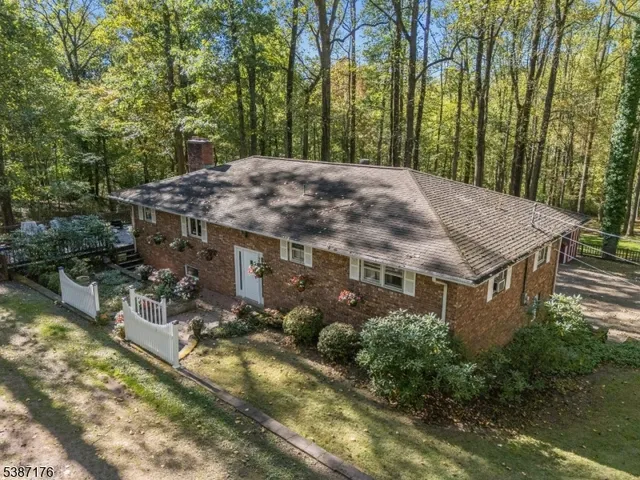 a view of a house with a yard and large trees