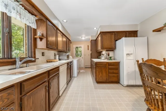 a kitchen with a sink a refrigerator and a stove top oven