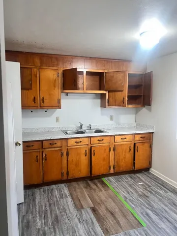 a kitchen with stainless steel appliances granite countertop wooden cabinets a sink and a large window