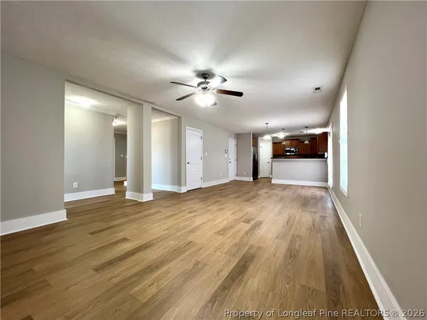 a view of empty room with wooden floor