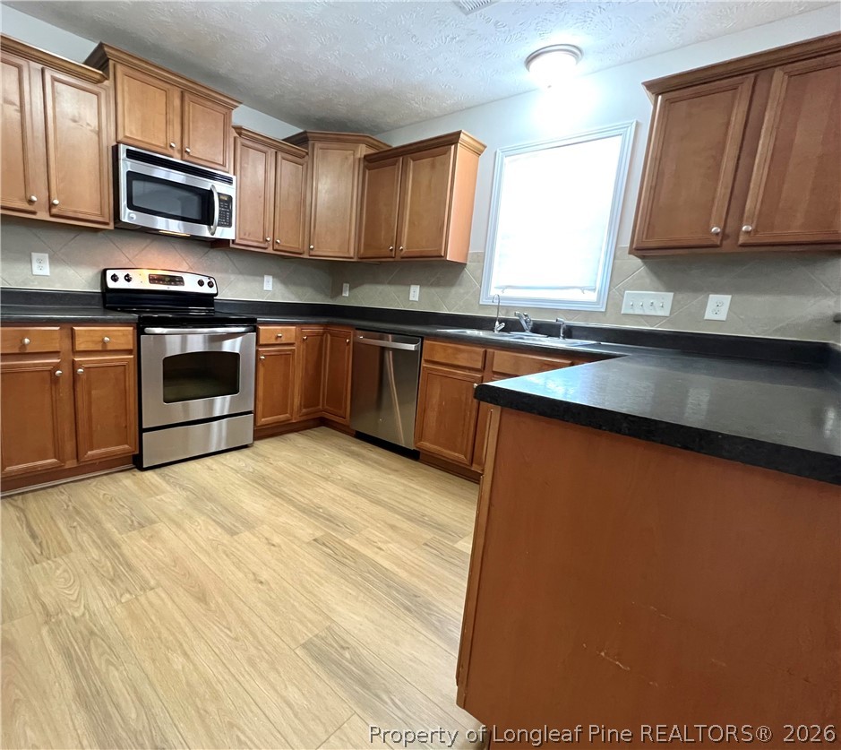 240 Declaration Drive Raeford, NC 28376 - Photo 9 of 37 a kitchen with stainless steel appliances granite countertop a stove a sink and a microwave