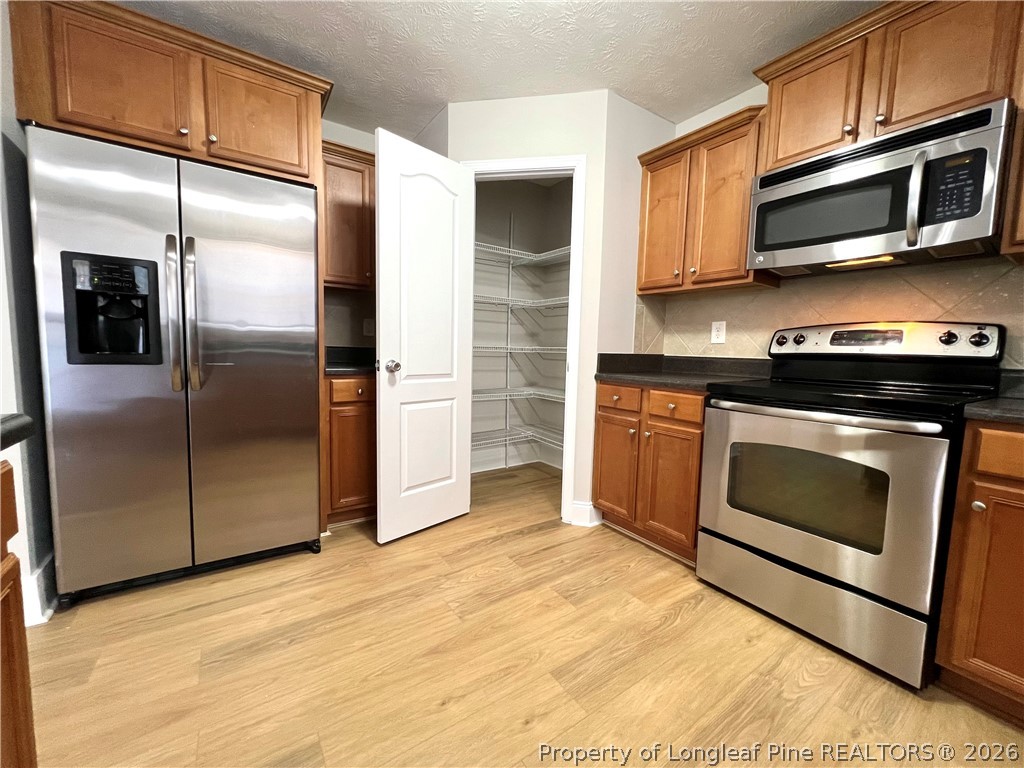 240 Declaration Drive Raeford, NC 28376 - Photo 10 of 37 a kitchen with stainless steel appliances granite countertop a stove a microwave and a refrigerator