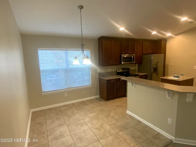 a kitchen with a sink a counter top space cabinets and stainless steel appliances
