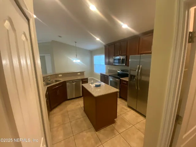 a kitchen with a sink a stove top oven and refrigerator