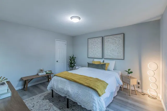 a bedroom with a bed and wooden floor