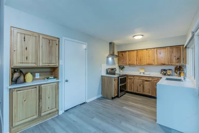 a kitchen with granite countertop a refrigerator cabinets and wooden floor