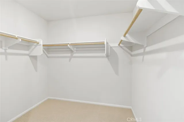 a view of walk in closet with empty racks