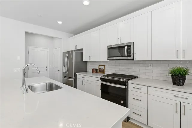 a kitchen with granite countertop a sink stove and refrigerator