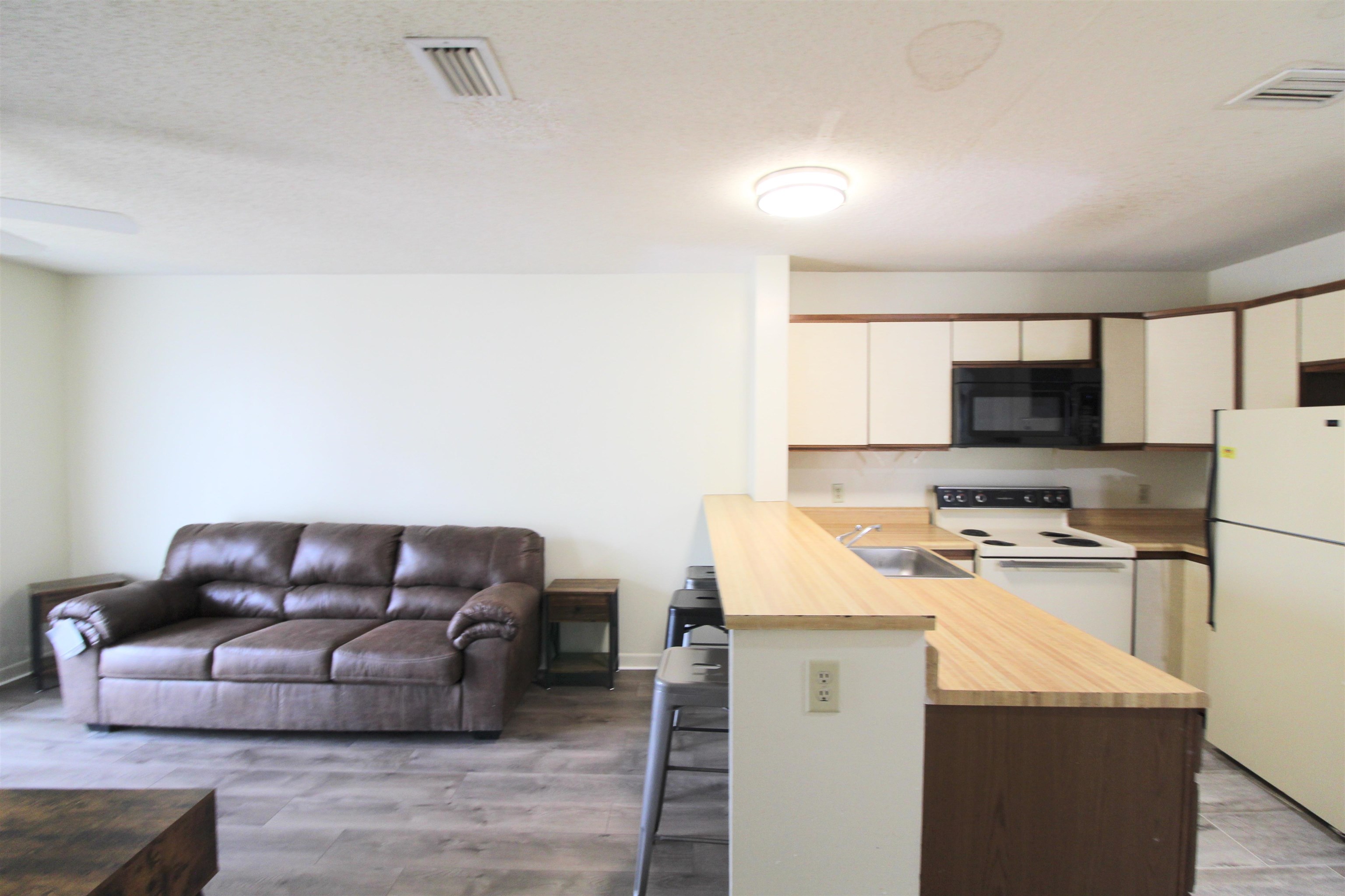 1336 Hunters Road, Unit G Harrisonburg, VA 22801 - Photo 24 of 42 a living room with stainless steel appliances kitchen island granite countertop a couch and a stove top oven