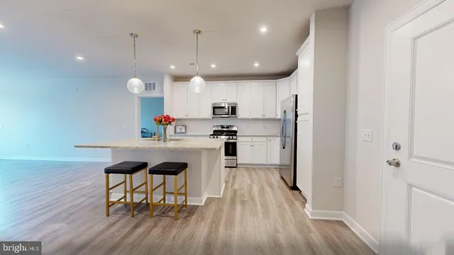 a kitchen with kitchen island white cabinets and stainless steel appliances