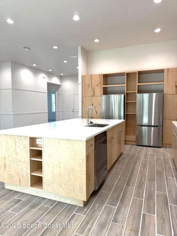 a large white kitchen with a large counter top and stainless steel appliances