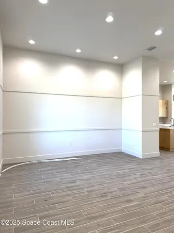 a view of a room with an empty space and wooden floor