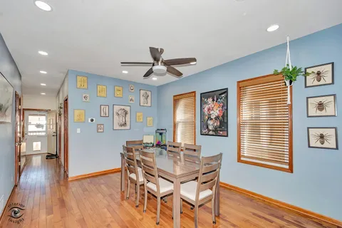 a dining room with wooden floor and a ceiling fan