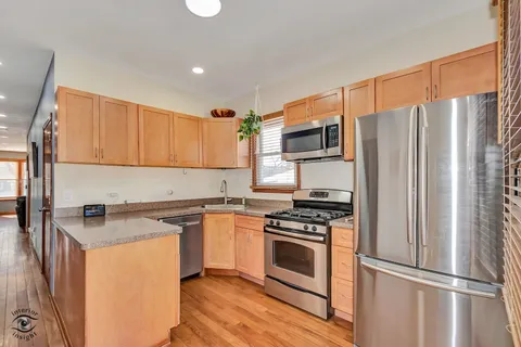 a kitchen with a refrigerator sink and stove top oven