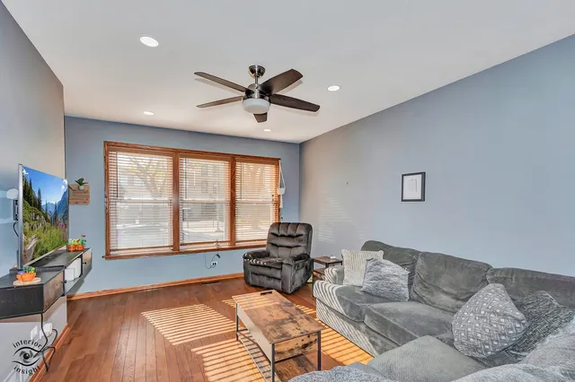 a living room with furniture and a flat screen tv with wooden floor