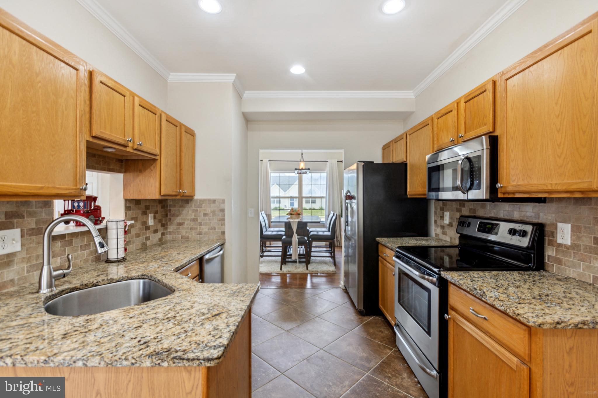 17 Brook Ramble Lane Townsend, DE 19734 - Photo 20 of 35 a kitchen with stainless steel appliances granite countertop a sink stove and refrigerator