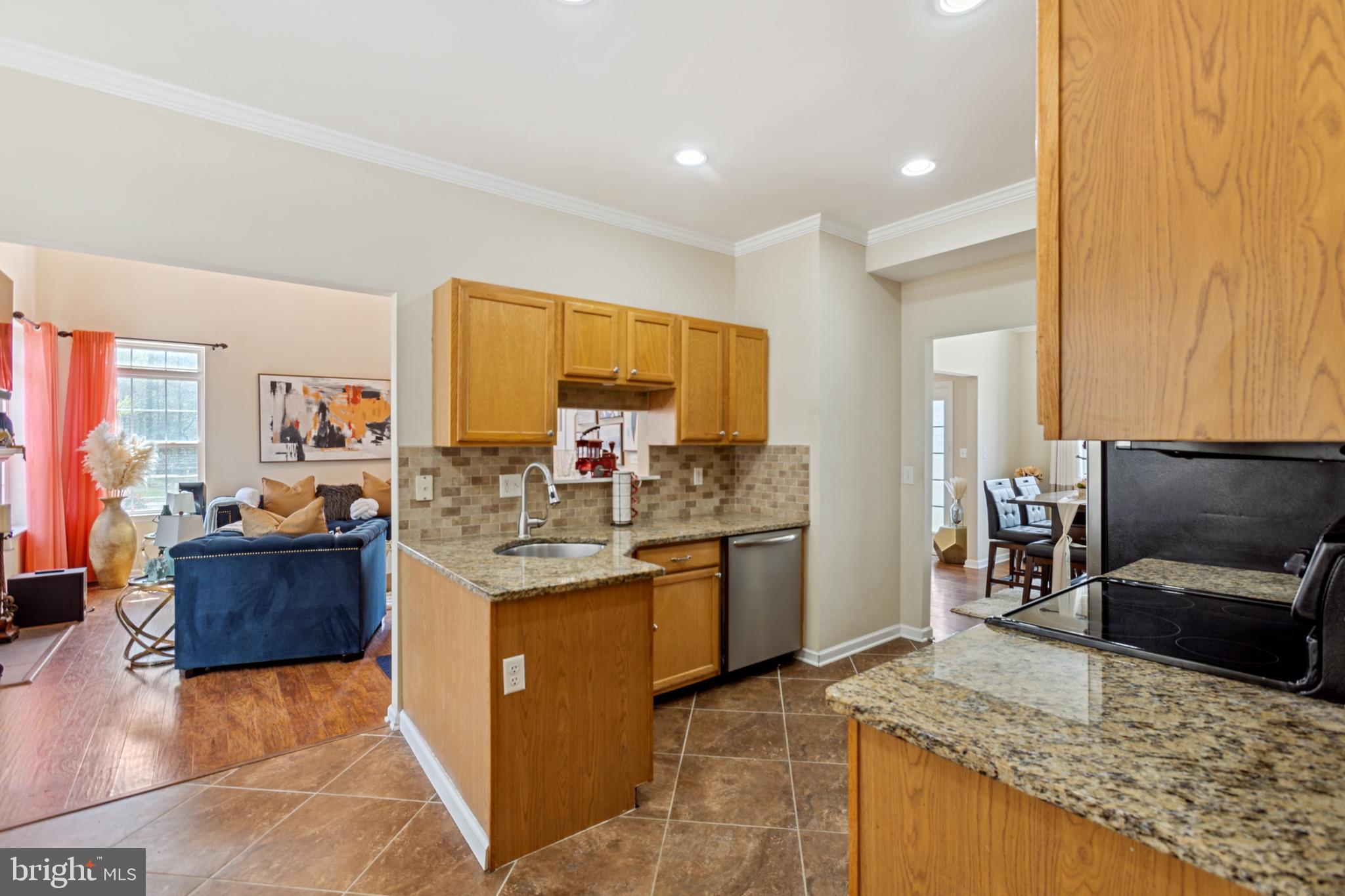 17 Brook Ramble Lane Townsend, DE 19734 - Photo 21 of 35 a kitchen with stainless steel appliances granite countertop a sink stove and refrigerator