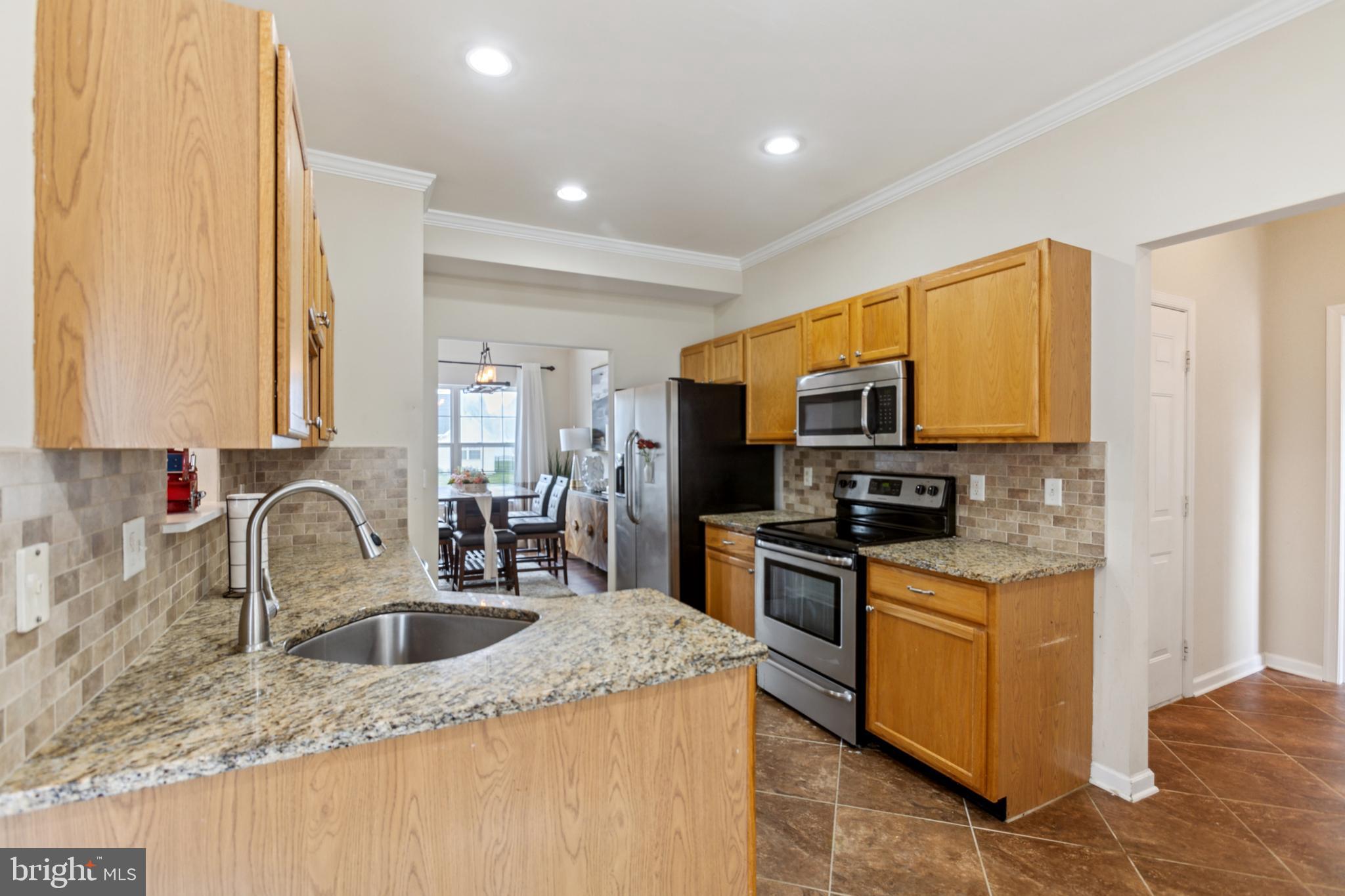 17 Brook Ramble Lane Townsend, DE 19734 - Photo 10 of 35 a kitchen with stainless steel appliances granite countertop a sink stove and refrigerator
