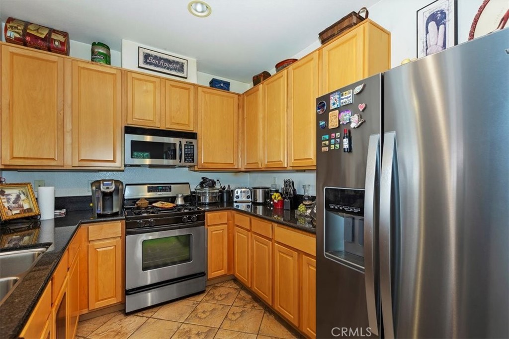 7331 Shelby Place, Unit U140 Rancho Cucamonga, CA 91739 - Photo 5 of 23 a kitchen with stainless steel appliances granite countertop a refrigerator stove and microwave