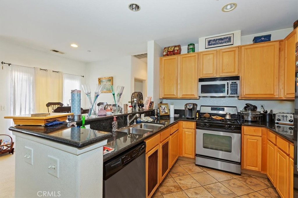 7331 Shelby Place, Unit U140 Rancho Cucamonga, CA 91739 - Photo 6 of 23 a kitchen with stainless steel appliances a stove sink microwave and cabinets