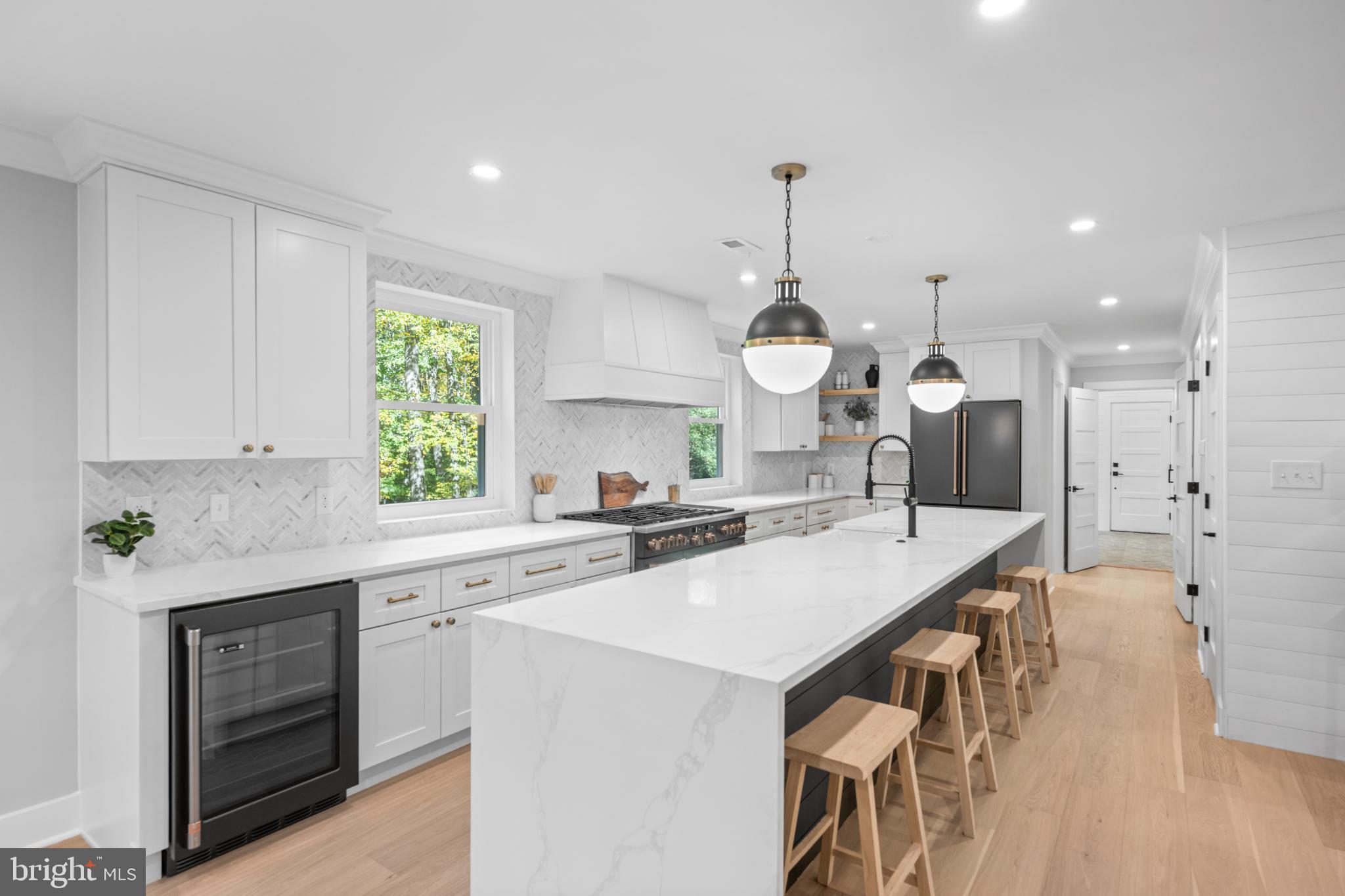 3053 Sidley Hill Road Malvern, PA 19355 - Photo 12 of 53 a kitchen with a stove a sink a kitchen island with wooden cabinets and wooden floor