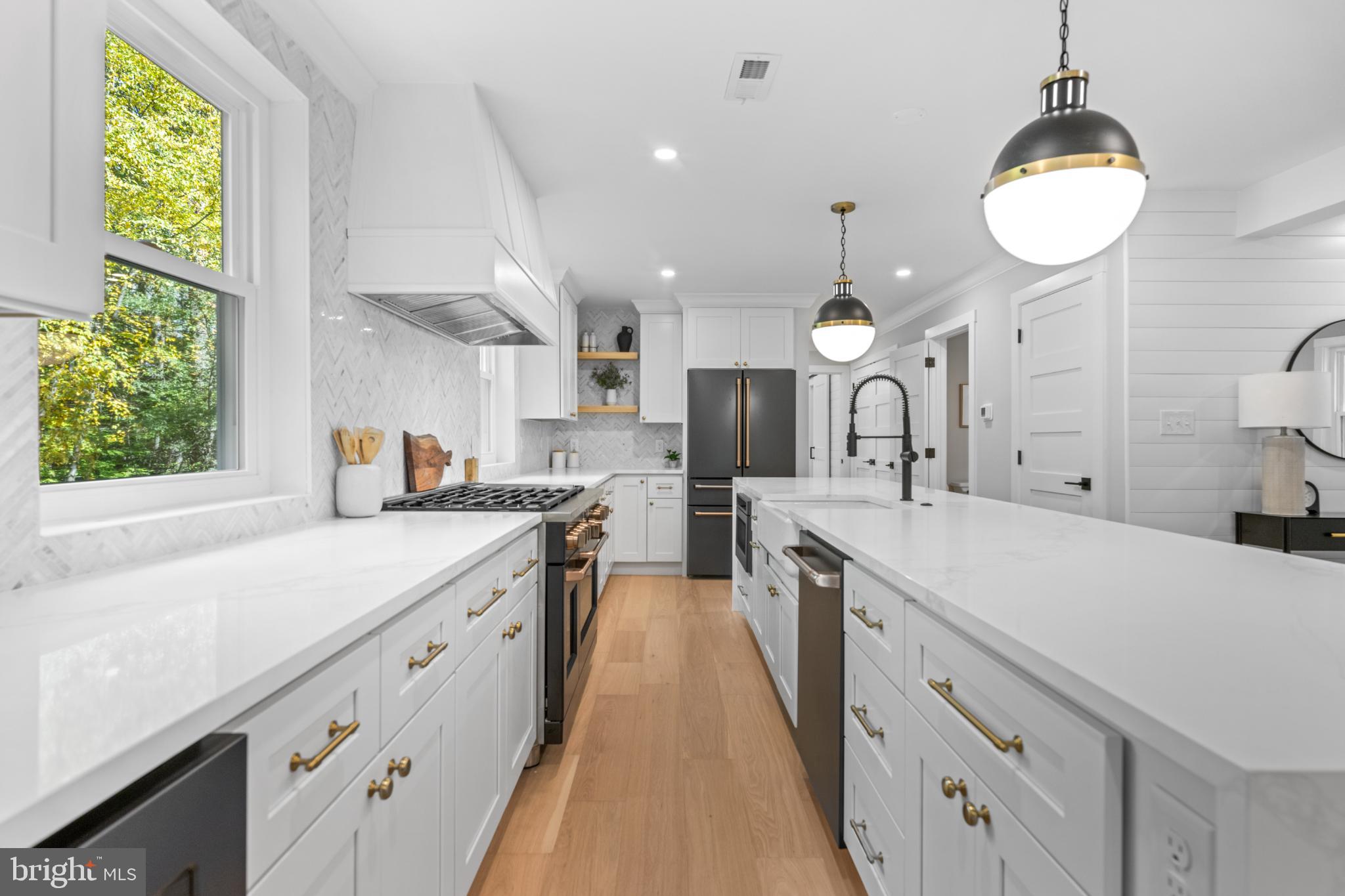 3053 Sidley Hill Road Malvern, PA 19355 - Photo 15 of 53 a large kitchen with kitchen island a large counter space a sink appliances and a window