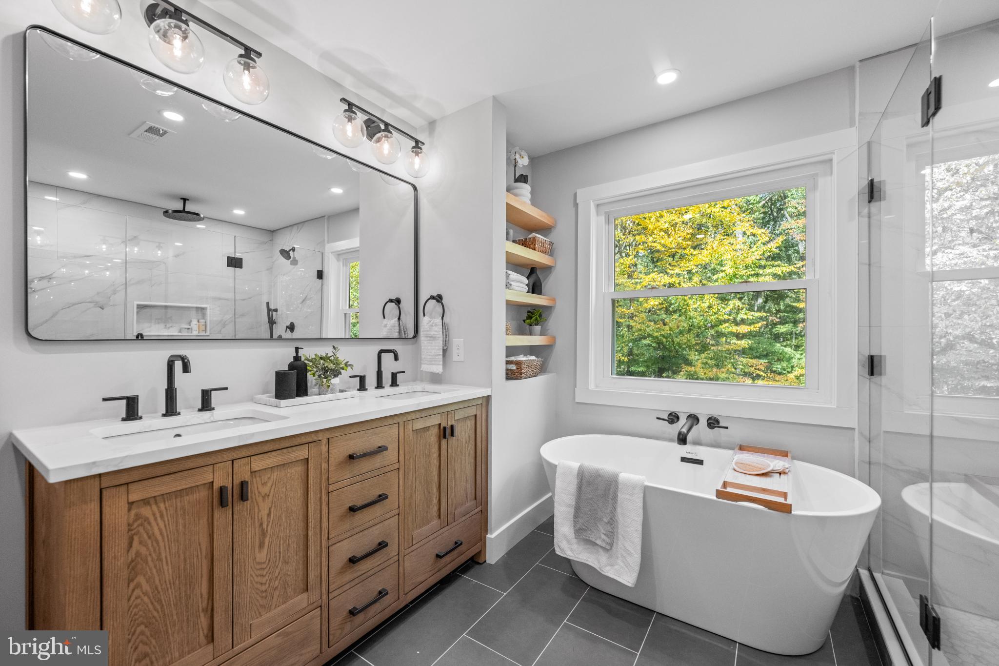 3053 Sidley Hill Road Malvern, PA 19355 - Photo 33 of 53 a bathroom with a double vanity sink a mirror and a bathtub