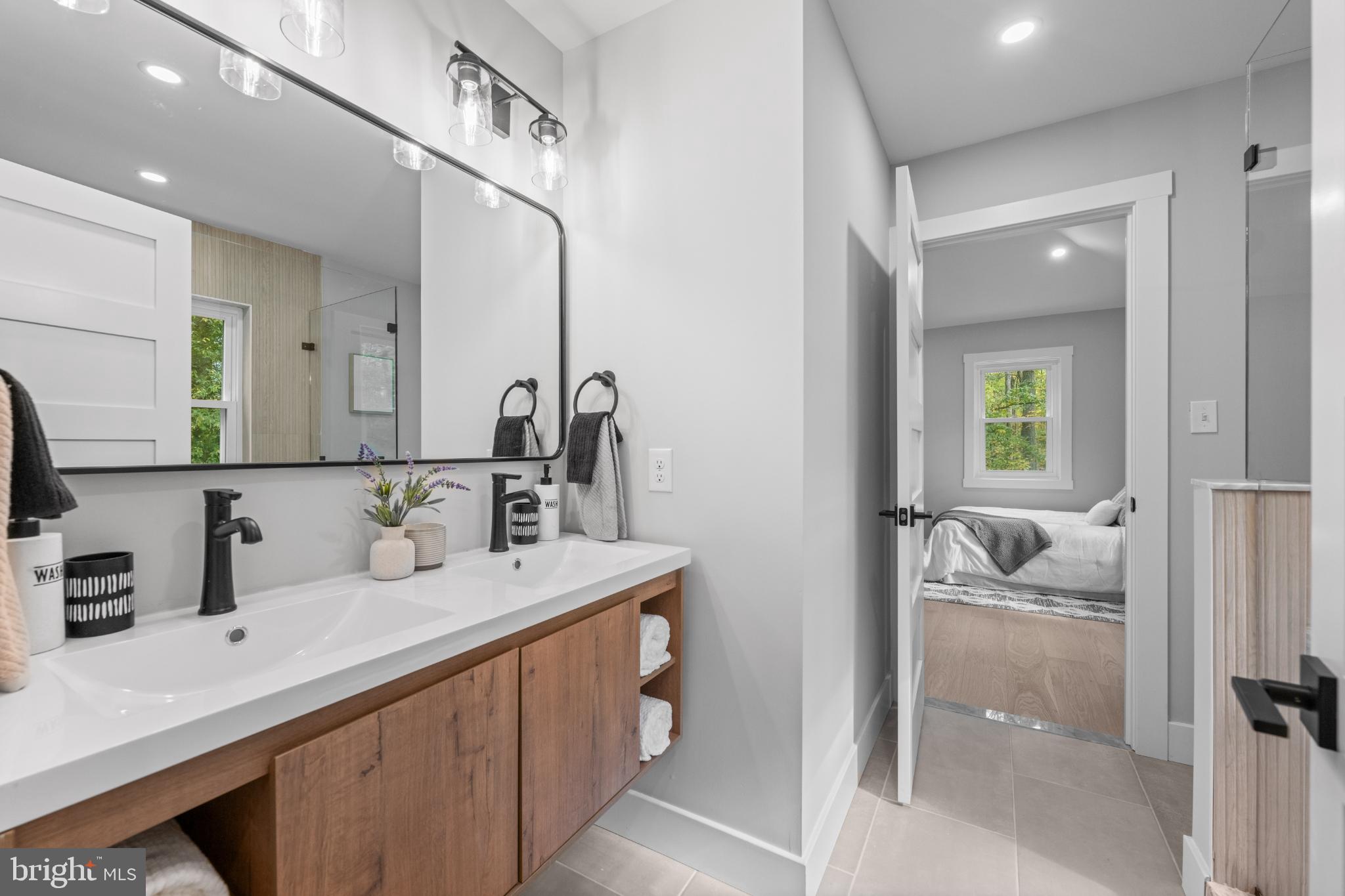 3053 Sidley Hill Road Malvern, PA 19355 - Photo 44 of 53 a en suite bathroom with a double vanity sink a mirror and shower