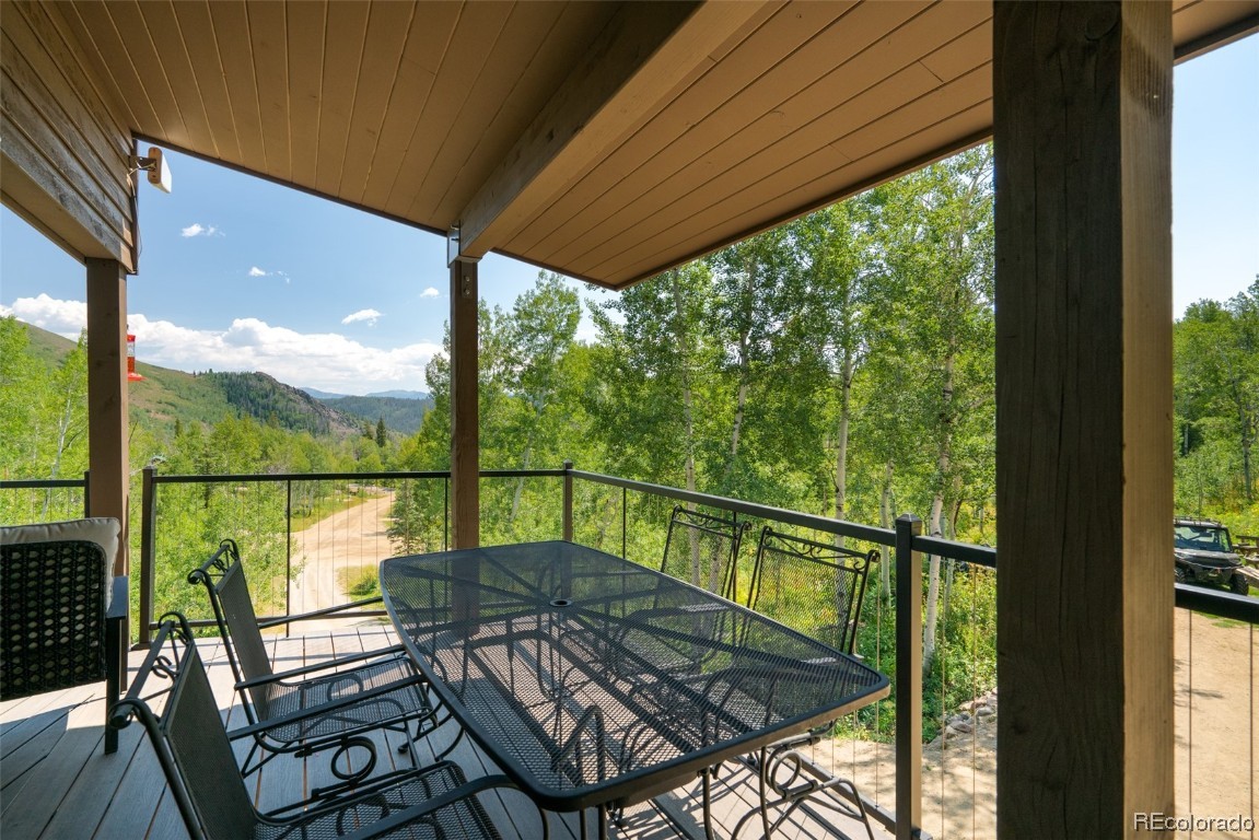 58195 Jupiter Place Clark, CO 80428 - Photo 3 of 29 a view of a balcony with chairs and wooden floor