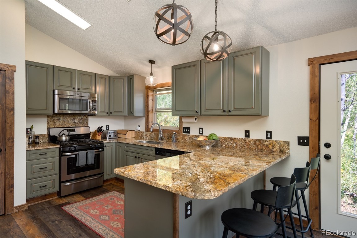 58195 Jupiter Place Clark, CO 80428 - Photo 4 of 29 a kitchen with kitchen island granite countertop a sink and stove