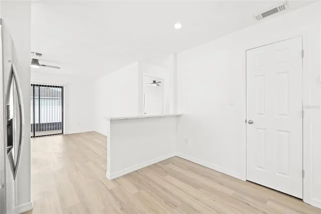 an empty room with wooden floor and mirror