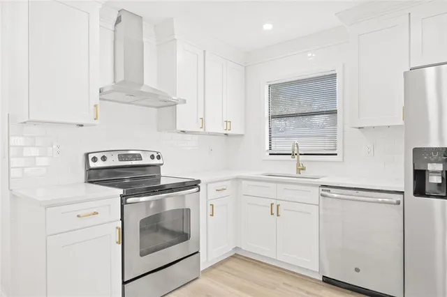 a kitchen with cabinets appliances a sink and a window