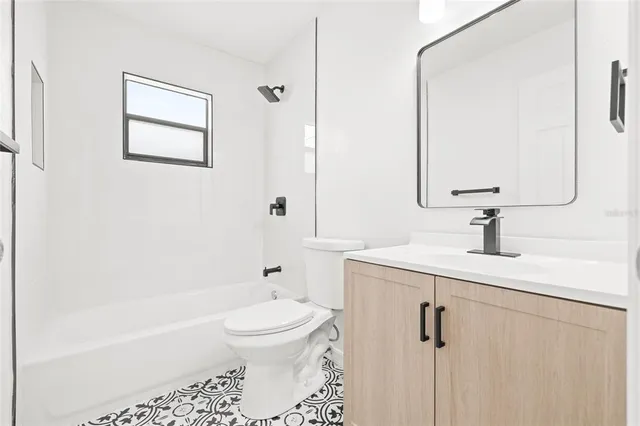 a bathroom with a bathtub shower sink vanity and toilet