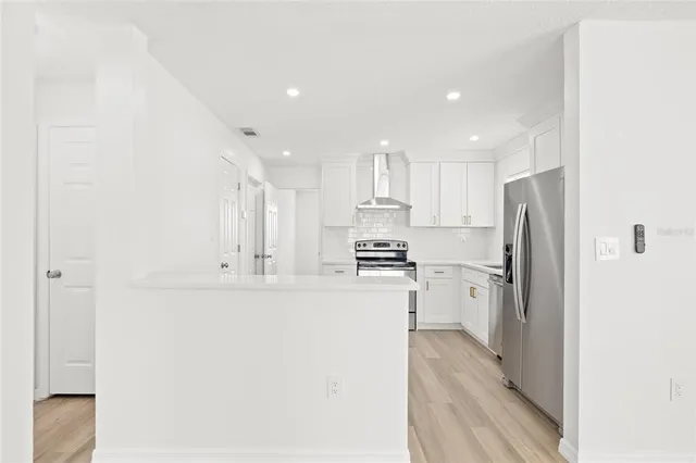 a kitchen with stainless steel appliances a refrigerator and a stove top oven