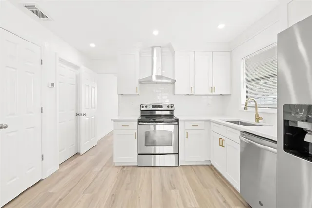a kitchen with granite countertop white cabinets and white appliances