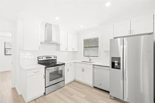a kitchen with white cabinets and white appliances