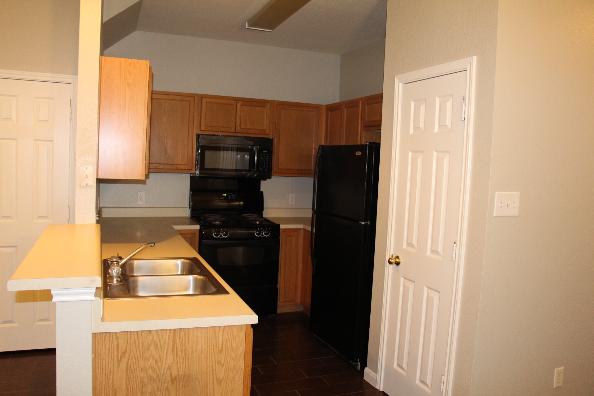 14109 Harris Ridge Boulevard, Unit A & B Pflugerville, TX 78660 - Photo 15 of 22 Functional layout defines this kitchen, featuring wood cabinetry and dark flooring.