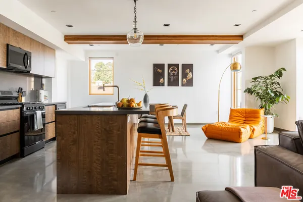 a living room with furniture a flat screen tv and a window